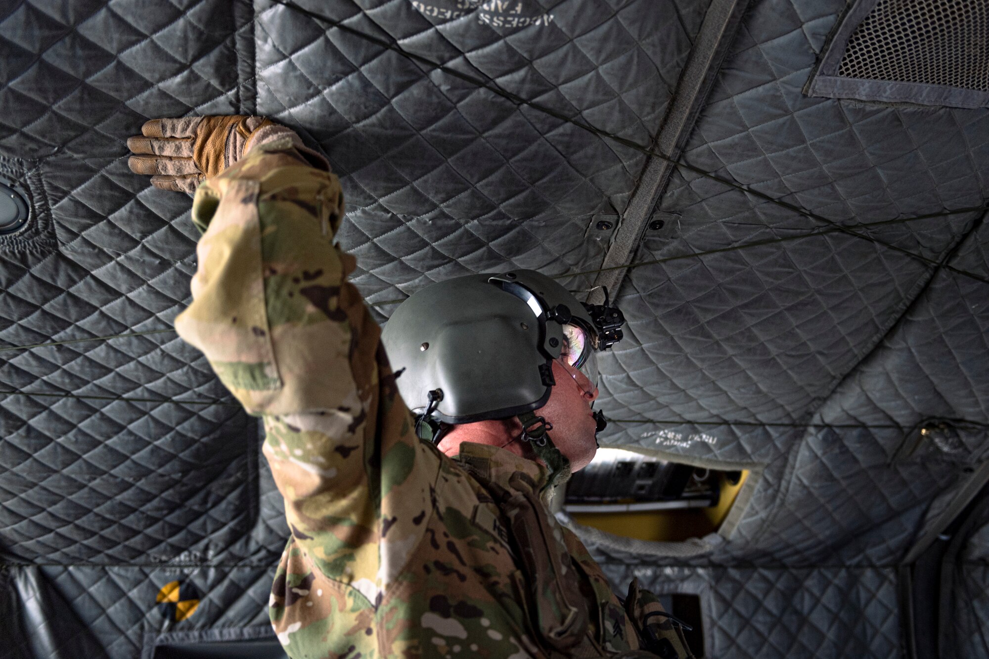 A photo of a Soldier touching the ceiling of a CH-47 Chinook