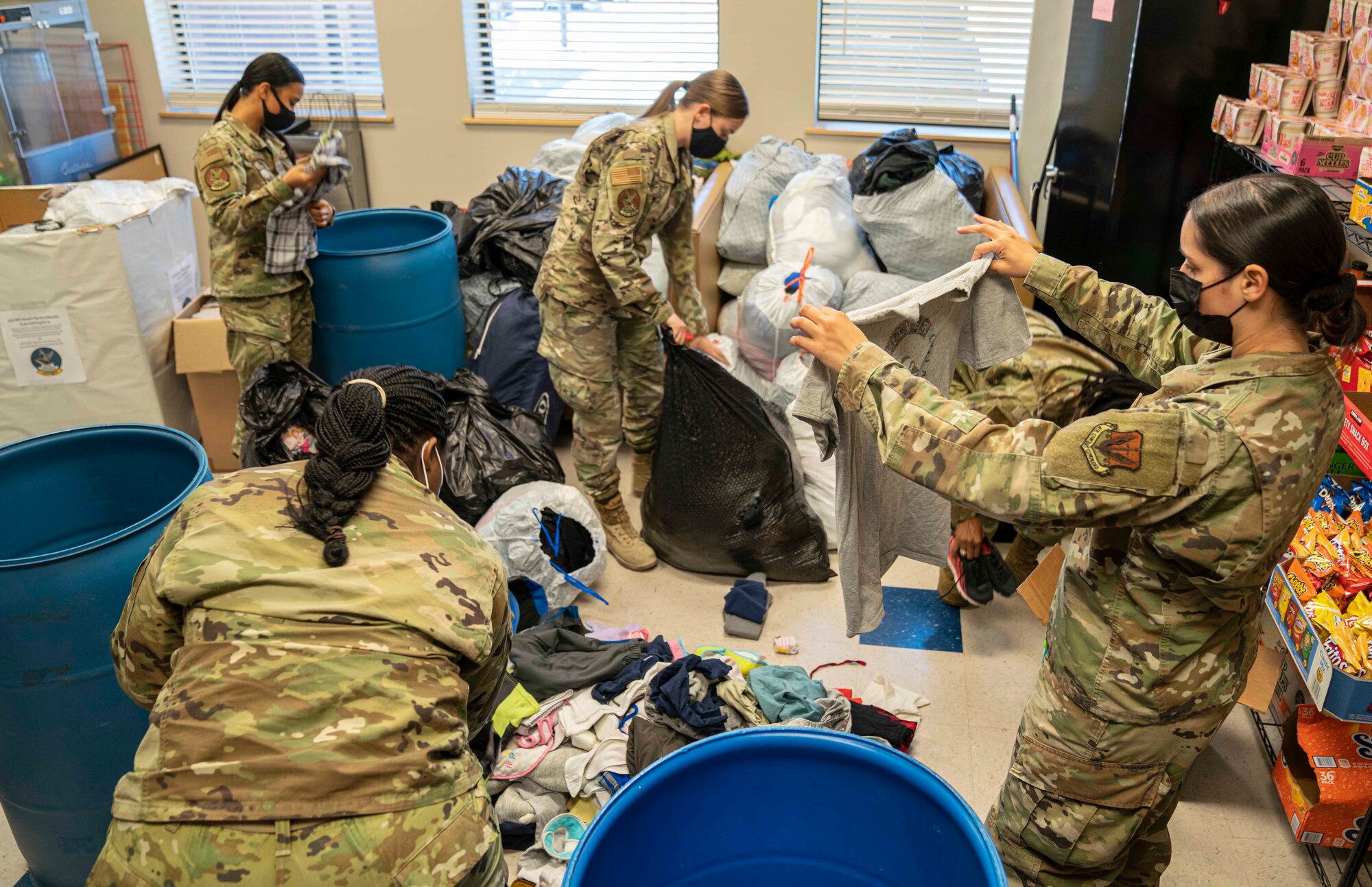 Airmen from the 432nd Maintenance Squadron sort through clothing donations.
