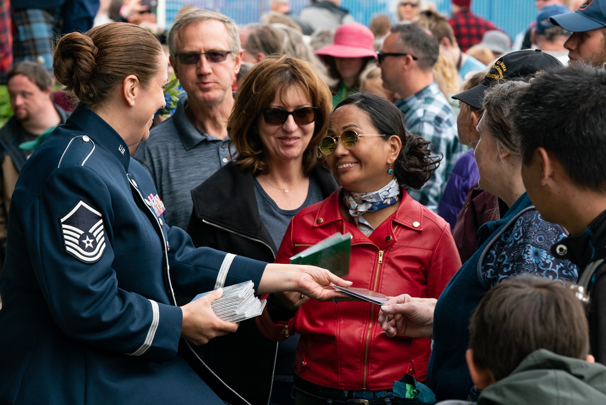 U.S. Air Force Master Sgt. Julia Cuevas, U.S. Air Force Band ensemble Celtic Aire traditional Irish instrumentalist and vocalist, hands out CDs and meets with audience members after a show at the Alaska Scottish Highland Games in Palmer, Alaska, June 26, 2021.