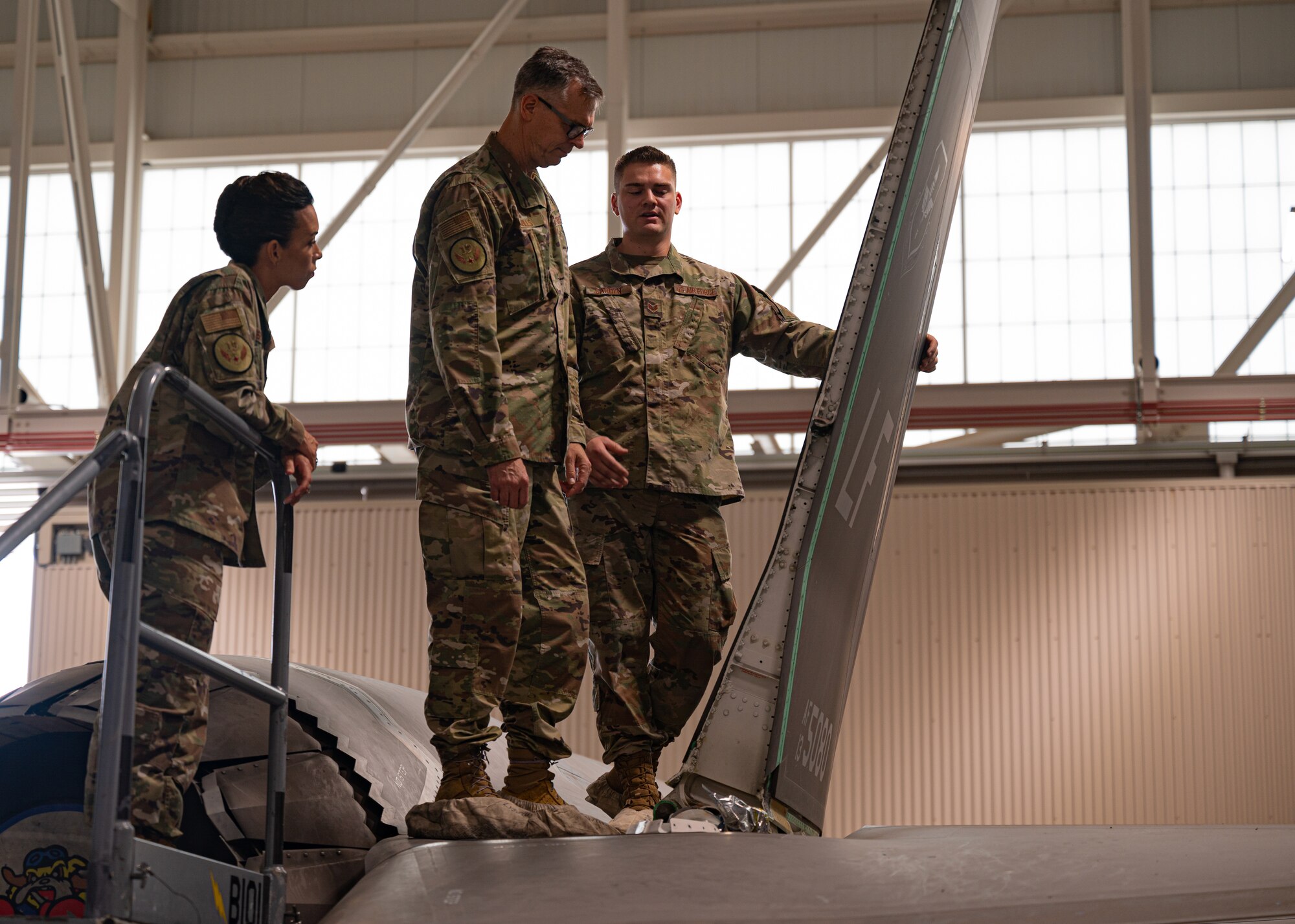 U.S. Air Force Staff Sgt. Tanner Carden, right, 308th Aircraft Maintenance Unit dedicated crew chief, speaks with U.S. Air Force Maj. Gen. Craig Wills, center, 19th Air Force commander, and U.S. Air Force Chief Master Sgt. Kristina Rogers, left, 19th AF command chief, about the components of an F-35 Lightning II, June 29, 2021, at Luke Air Force Base, Arizona. Leadership from the 19th AF visited Luke AFB to engage with 56th Fighter Wing members while gaining a better understanding of the successes and challenges faced by the wing. The 56th FW’s mission is to train the world’s greatest fighter pilots and combat-ready Airmen. (U.S. Air Force photo by Airman 1st Class Dominic Tyler)