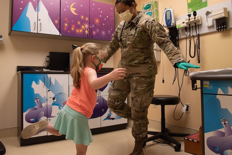 U.S. Air Force Senior Airman Julia Vallejo, 375th Health Care Operations Squadron Pediatrics Clinic aerospace medical technician, leads the patient through a balance test on Scott Air Force Base, Illinois, June 28, 2021. Vallejo used the test to gauge motor performance in the patient. (U.S. Air Force photo by Airman 1st Class Stephanie Henry)