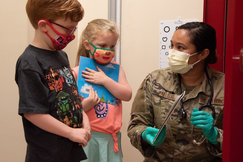 U.S. Air Force Senior Airman Julia Vallejo, 375th Health Care Operations Squadron Pediatrics Clinic aerospace medical technician gives out books to patients after their wellness checks on Scott Air Force Base, Illinois, June 28, 2021. The clinic provides books to their patients to encourage literacy for all ages. (U.S. Air Force photo by Airman 1st Class Stephanie Henry)