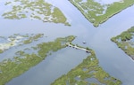 An aerial shot of the tidal flats and marshlands in southern Louisiana, taken June 25, provides an idea of just how difficult oil clean-up operations would be in such a shallow and densely vegetated environ. Coast Guard members and civilian boat crews are working to boom off inlets to these areas in order to prevent contamination of one of the Gulf Coast's most sensitive ecosystems.