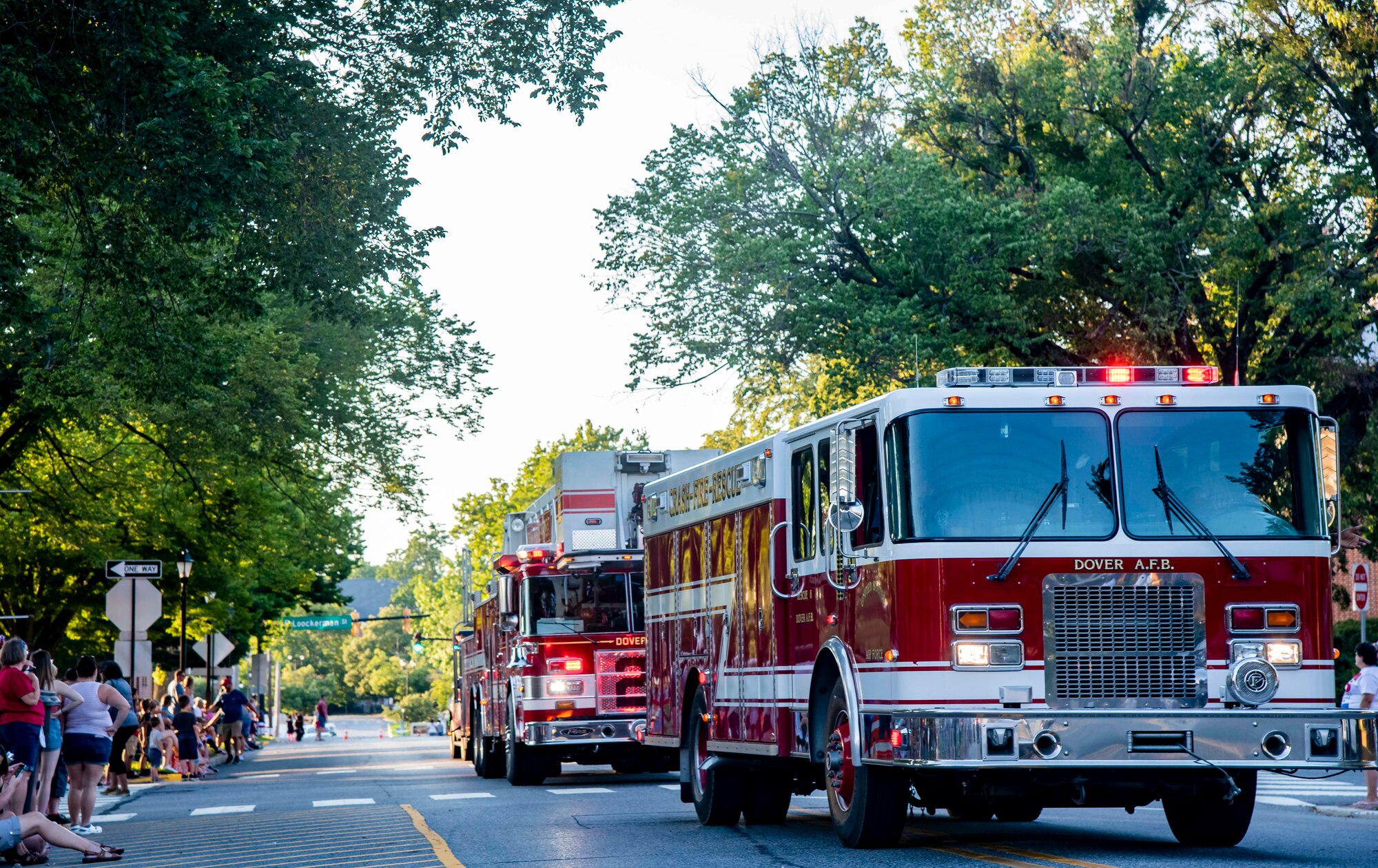 Fire trucks from the 436th Civil Engineer Squadron fire department drive in the annual Fourth of July Celebration parade in Dover, Delaware, July 4, 2021. The celebration also included a reading of the Declaration of Independence, tours of the Old State House, musical entertainment and a fireworks display. (U.S. Air Force photo by Senior Airman Stephani Barge)