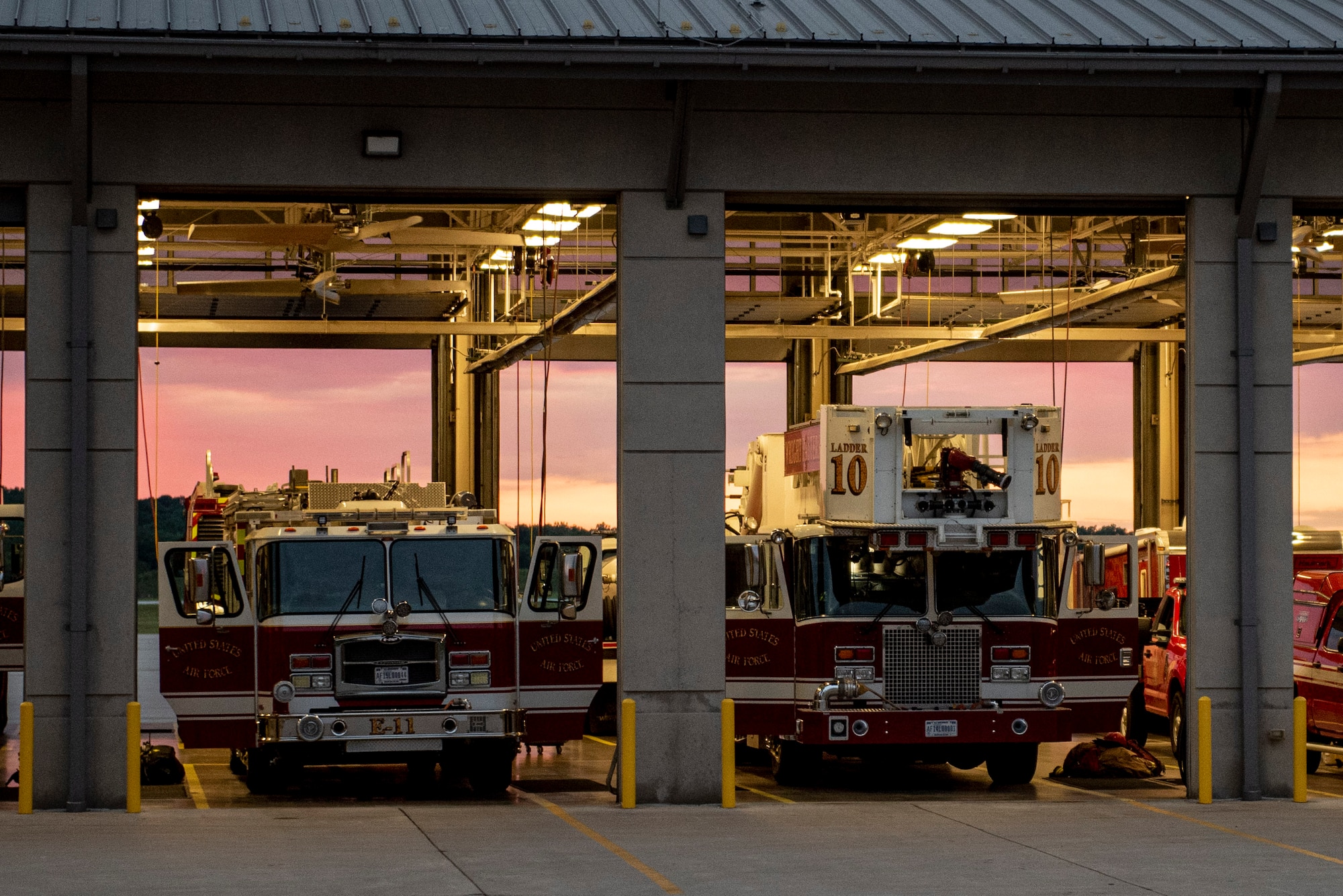 Two trucks sit with their doors open to allow for quick access in case of emergency inside Fire station 1 located in Area A of Wright-Patterson Air Force Base, Ohio, which is one of three stations ready to respond whenever the call for help occurs. The stations are strategically located around the base to ensure a response time of 5 minutes or less when the call comes in. (U.S. Air Force photo by Wesley Farnsworth)
