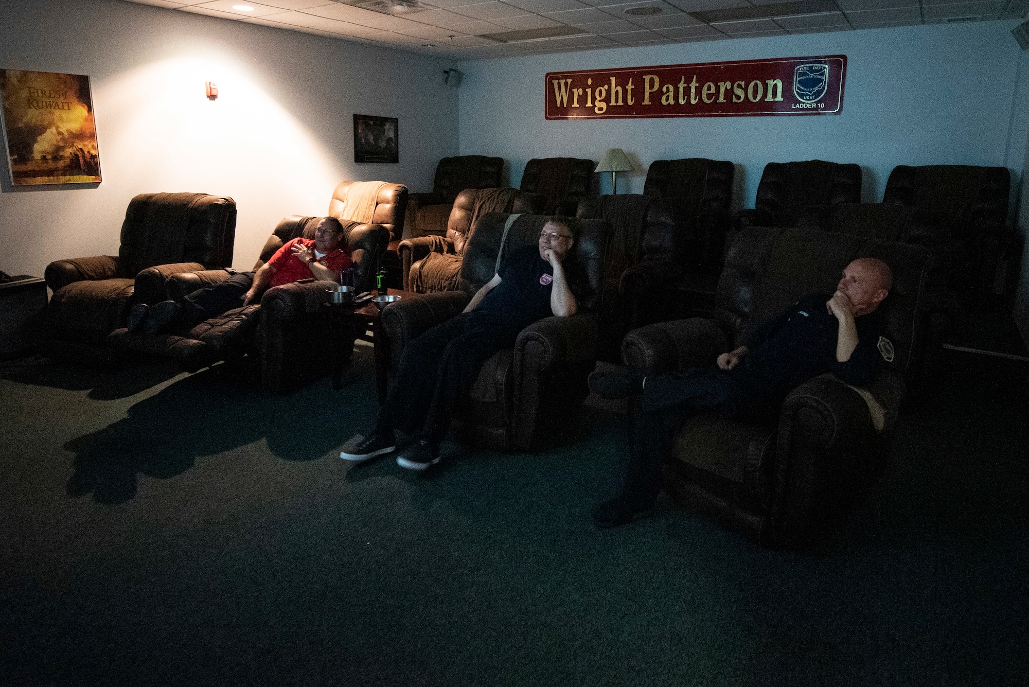 Firefighters take a moment to watch a movie during their evening downtime inside station 1, June 23, 2021, at Wright-Patterson Air Force Base, Ohio.  The base fire department has three stations strategically located around the base to ensure a response time of 5 minutes or less when the call comes in. (U.S. Air Force photo by Wesley Farnsworth)