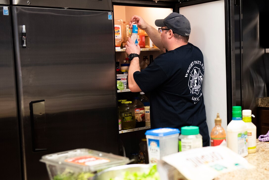 Zack Thorpe, a firefighter with the 788th Civil Engineer Fire Department, prepares dinner for Station 1, June 23, 2021, at Wright-Patterson Air Force Base, Ohio. The fire department is on call 24/7 all year and capable of responding anywhere on base within 5 minutes when a call for help comes in. (U.S. Air Force photo by Wesley Farnsworth)