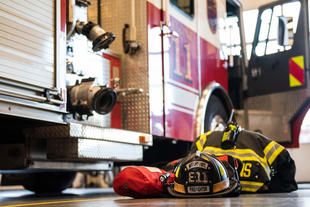 Bunker gear sits staged next to a fire truck belonging to the 788th Civil Engineer Fire Department inside the bays at Station 1, June 23, 2021, at Wright-Patterson Air Force Base, Ohio. The fire department is on call 24/7 all year and capable of responding anywhere on base within 5 minutes when a call for help comes in. (U.S. Air Force photo by Wesley Farnsworth)