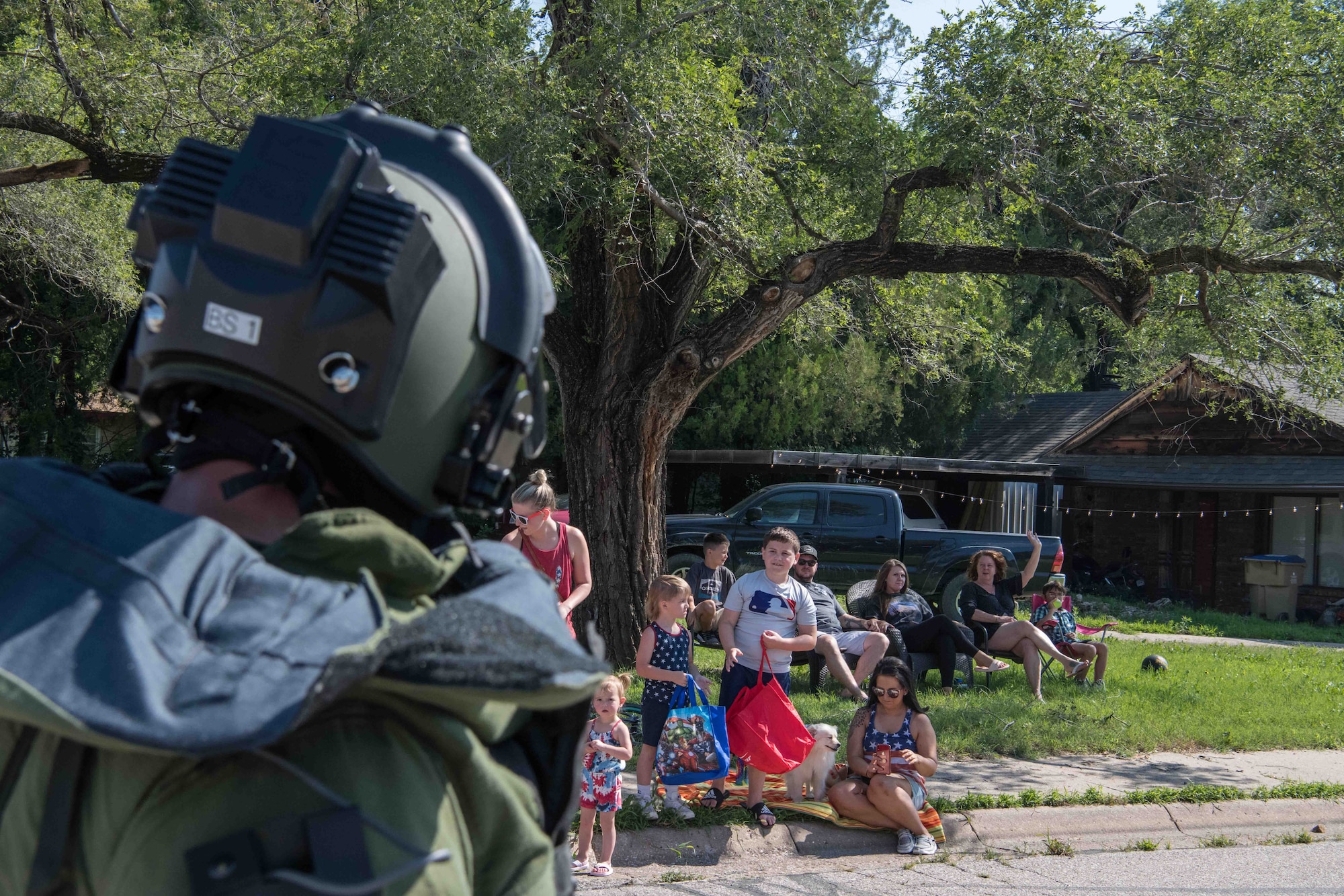 Master Sgt. John Wawrzynski, 22nd Civil Engineer Squadron explosive ordnance disposal flight superintendent, waves to parade attendees during the Derby Independence Day parade July 3, 2021, in Derby, Kansas. Wawrzynski displayed a blast-proof body suit and helmet weighing approximately 96 pounds throughout the parade. (U.S. Air Force photo by Senior Airman Marc A. Garcia)