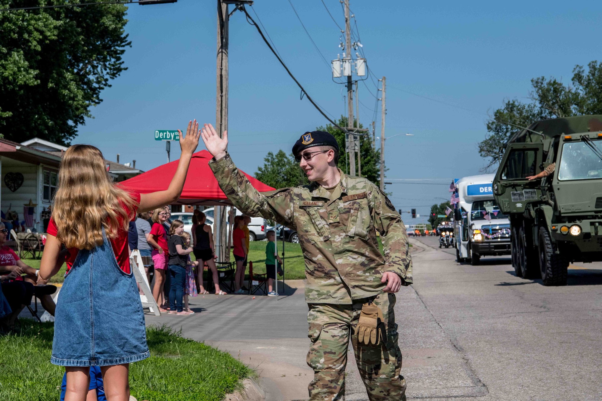 Senior Airman Brandon Holland, 22nd Security Forces Squadron patrolman, high fives a parade attendee during Derby’s Independence Day parade July 3, 2021, in Derby, Kansas. McConnell Air Force Base had military members from the 184th Wing, 22nd Civil Engineer Squadron and 22nd SFS, participate in the annual parade for the city of Derby. (U.S. Air Force photo by Senior Airman Marc A. Garcia)
