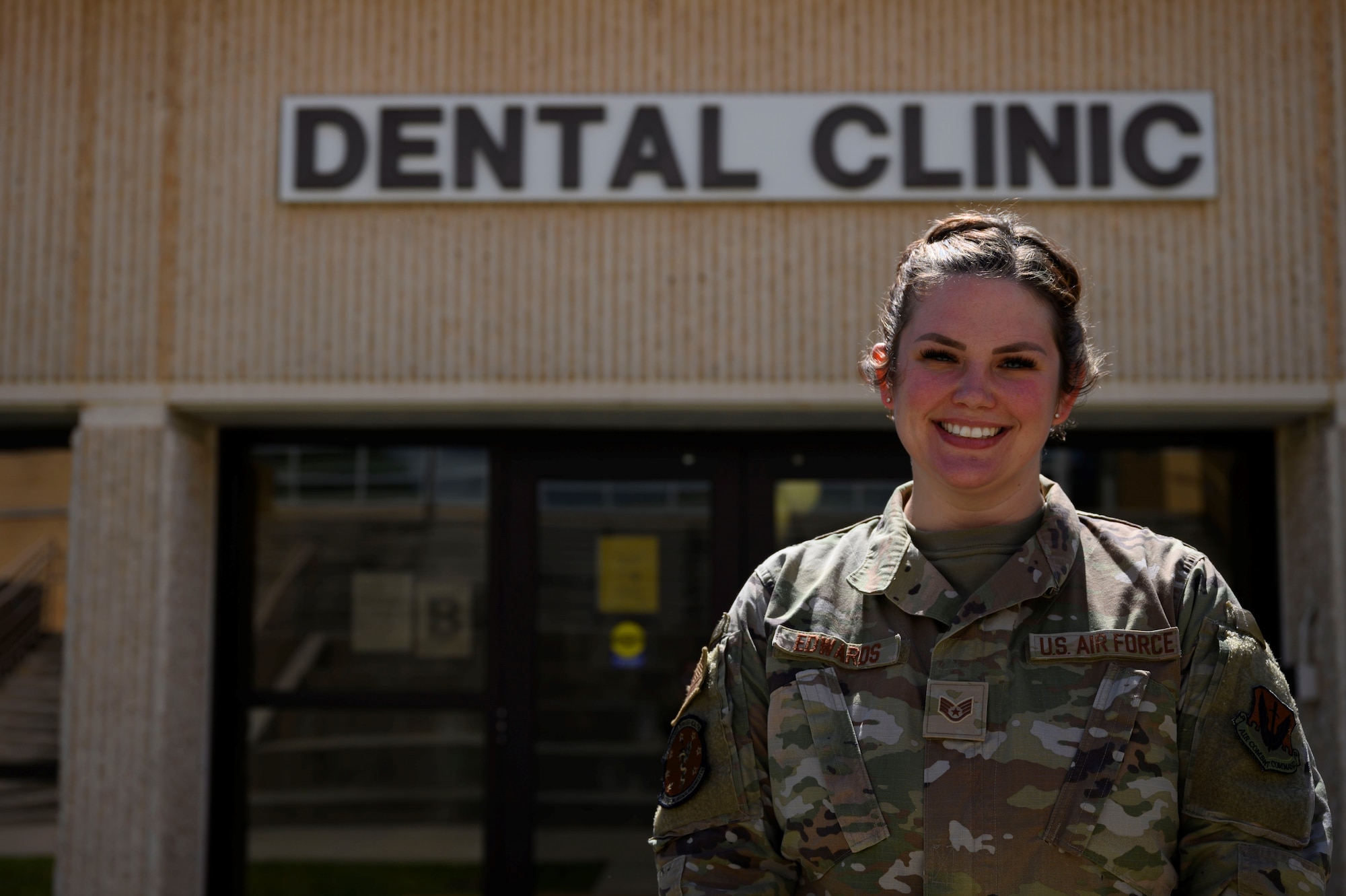 A photo of SSgt Brianna Edwards in front of Dental Clinic.