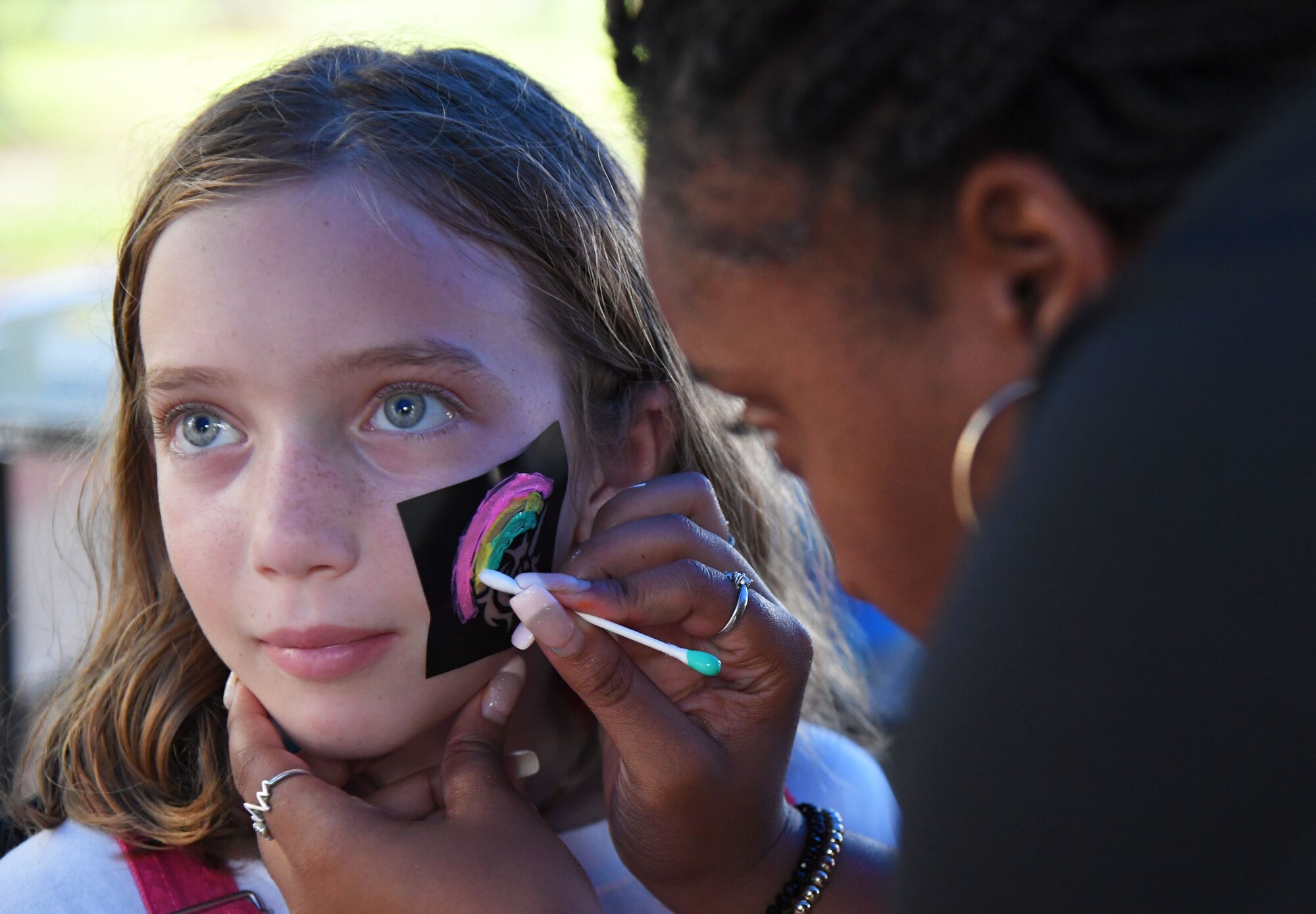 TaNessa Scott, 81st Force Support Squadron recreation assistant, applies face paint to Sidney Estridge, daughter of U.S. Air Force Col. Chris Estridge, 81st Medical Group commander, during Freedom Fest at Marina Park at Keesler Air Force Base, Mississippi, July 2, 2021. The event also included hot wings and watermelon eating competitions and fireworks. (U.S. Air Force photo by Kemberly Groue)