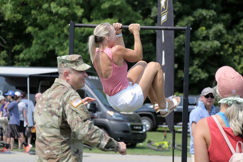 Renee Eckberg, a fitness coach from Oakfield, Wisconsin, performs Army Leg Tucks, one of six events in the U.S. Army’s new Army Combat Fitness Test, during the Fourth of July NASCAR Cup Series race at Road America, Elkhart Lake, Wisconsin, July 4, 2021.
