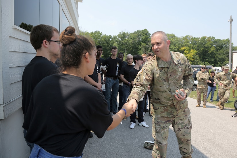 Brig. Gen. Ernest Litynski, Commanding General, 85th U.S. Army Reserve Support Command, presents his personal coin to Morgan Deleon, future Soldier, during the Fourth of July NASCAR Cup Series race at Road America, Elkhart Lake, Wisconsin, July 4, 2021.