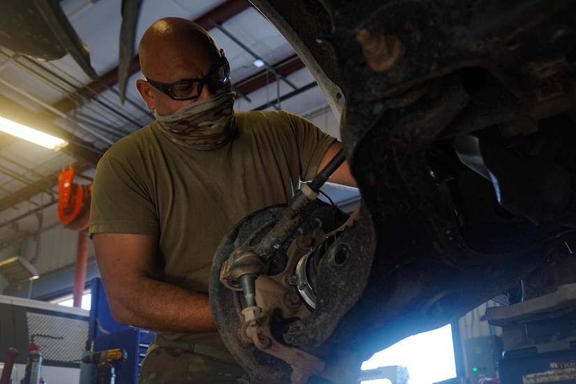 A soldier works on a vehicle.