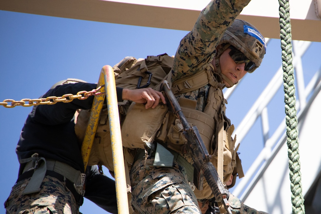 a rifleman with 1st Battalion, 5th Marines, 1st Marine Division, prepares to make a fast rope descent during a Fast Rope Masters Course at Camp Pendleton, California, May 11, 2021.
