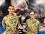 Air Force Airman and Space Force Guardian show their coins after graduation.