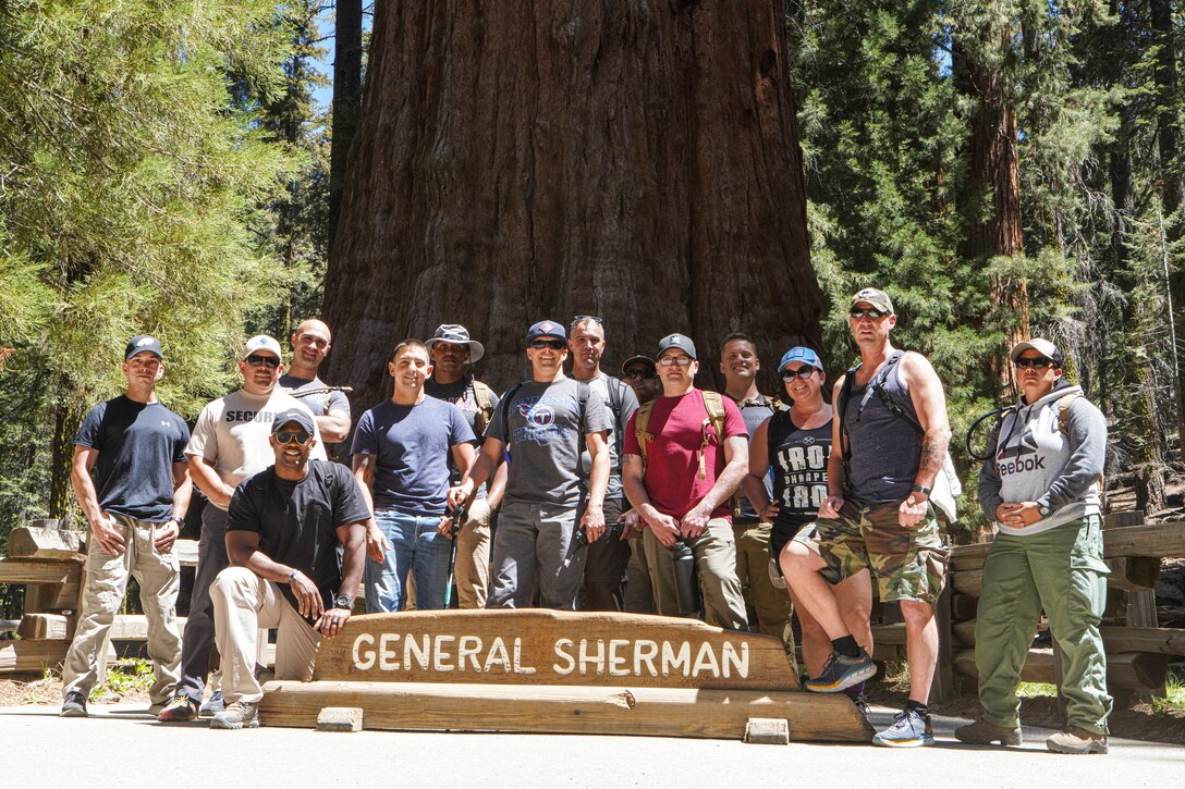 U.S. Marines with I Marine Expeditionary Force Information Group, pose for a group photo in front of the General Sherman Tree at Sequoia National Forest during a leadership retreat by Kaweah Lake, California, May 26, 2021. The three-day retreat in the Sequoia National Forest focused on connectedness and personal growth to increase individual and unit resilience. It provided participants with the tools and resources to shape their units' training programs, build character and equip their peers and subordinates with greater life resiliency skills. The interconnectedness of the roots of the Sequoia trees is a metaphor for the network of Marines and sailors that rely on each other through every rank and life situation. The trees are also a metaphor for unit Esprit-de-Corps that expands across a much larger national network. This inaugural retreat set the foundation for future, similar events that will include conditioning events, lectures, guided discussions and guest speakers. (U.S. Marine Corps Photo by Lance Cpl. Aidan Hekker)