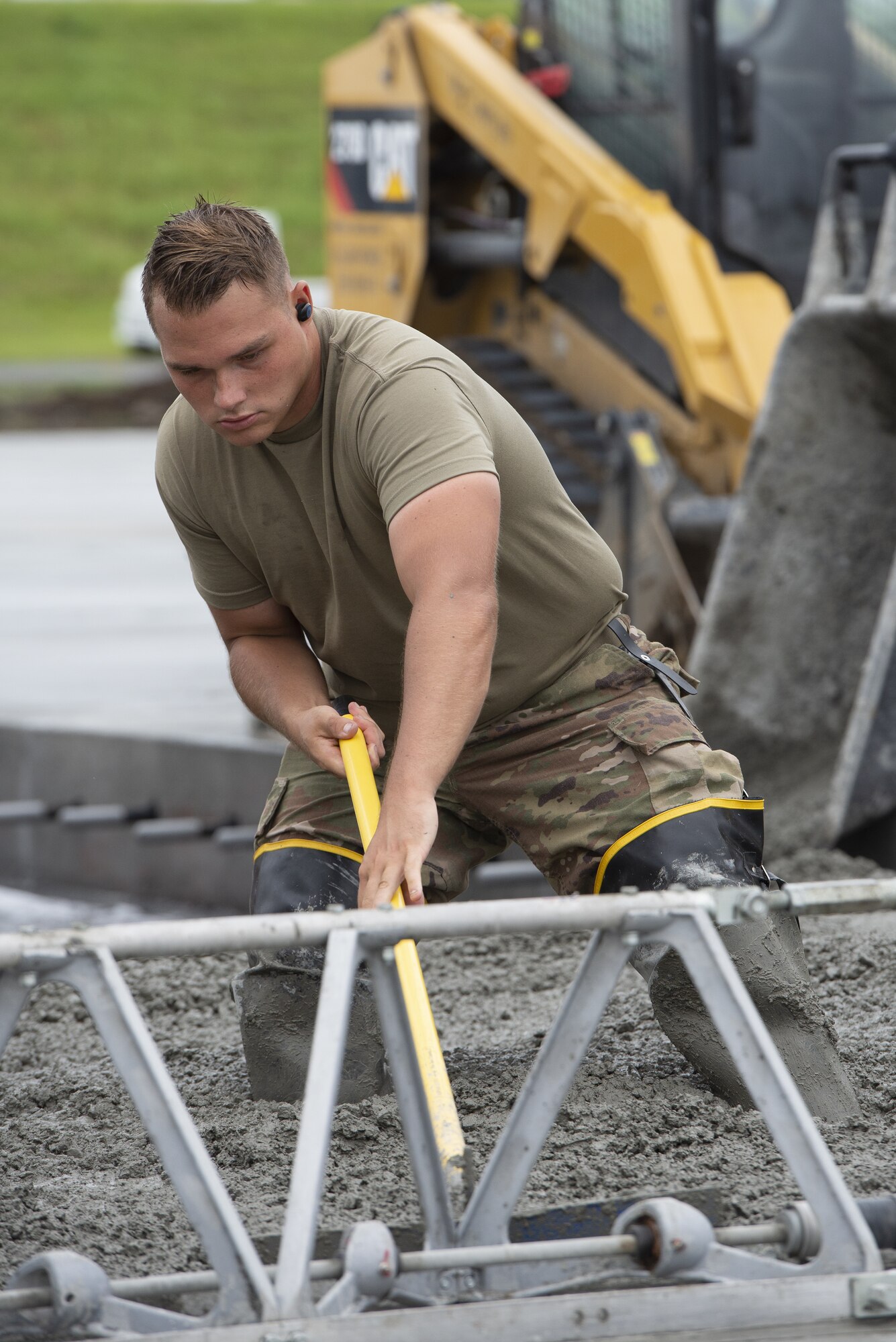 Senior Airman Kendall Allison, 819th RED HORSE Squadron structural journeyman, levels wet concrete as part of a construction project to expand a flightline apron June 30, 2021, at Yokota Air Base, Japan. The construction project requires Airmen assigned to the 823rd, 819th and 820th RED HORSE Squadrons to pour approximately 7,300 cubic meters of concrete and pave 650 tons of asphalt in a construction effort to increase aircraft parking capabilities at Yokota Air Base. The apron expansion is the first in an approximately four-year phased construction effort to enhance Yokota Air Base’s airlift mission capabilities. (U.S. Air Force photo by Tech. Sgt. Christopher Hubenthal)