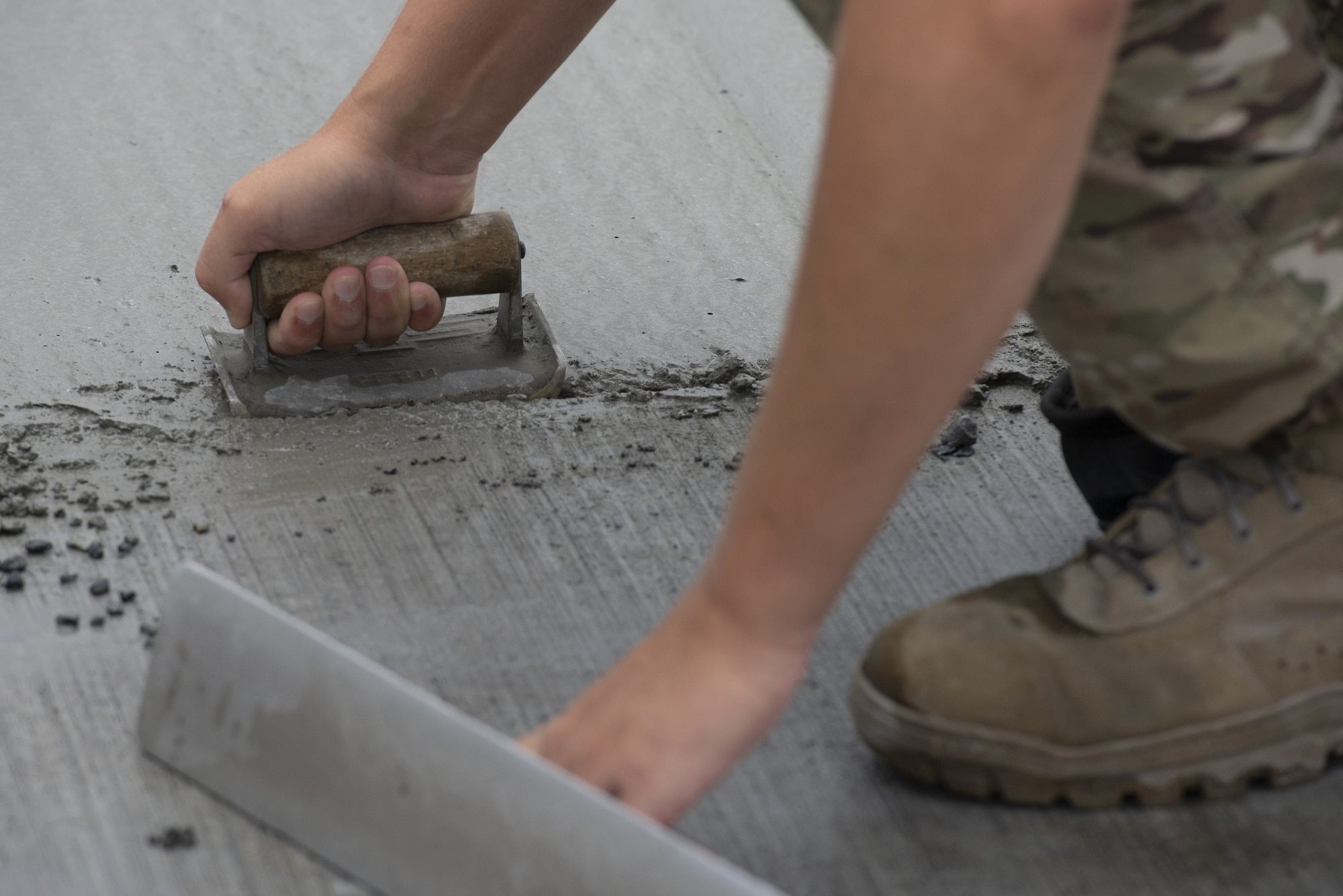 Staff Sgt. Andrew Vandell, 823rd RED HORSE Squadron structural craftsman, levels wet concrete as part of a construction project to expand a flightline apron June 30, 2021, at Yokota Air Base, Japan. Airmen assigned to the 823rd, 819th and 820th RED HORSE Squadrons, combined efforts to increase aircraft parking capabilities. The apron expansion is the first in an approximately four-year phased construction effort to enhance Yokota Air Base’s airlift mission and is the first 800th RED HORSE Group project within the U.S. Indo-Pacific. (U.S. Air Force photo by Tech. Sgt. Christopher Hubenthal)