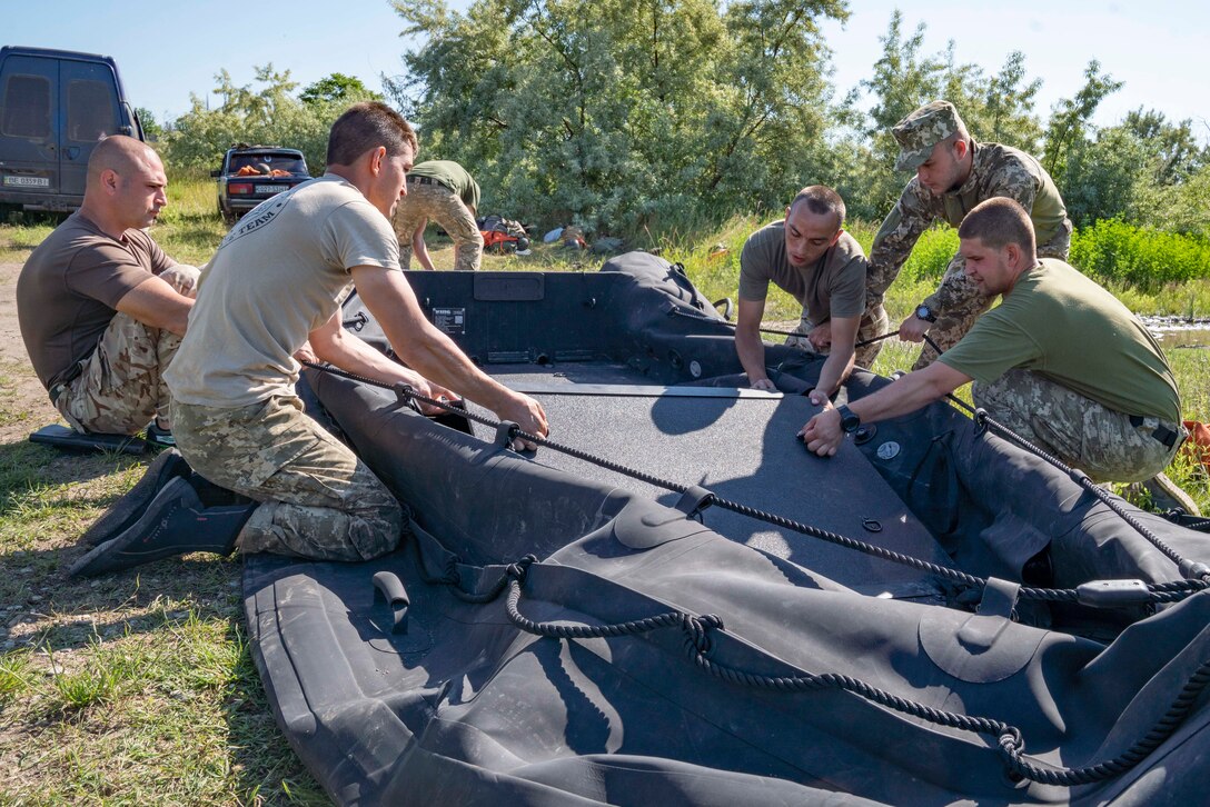 Ukrainian Marines with the 36th Marine Brigade carry a combat rubber reconnaissance craft