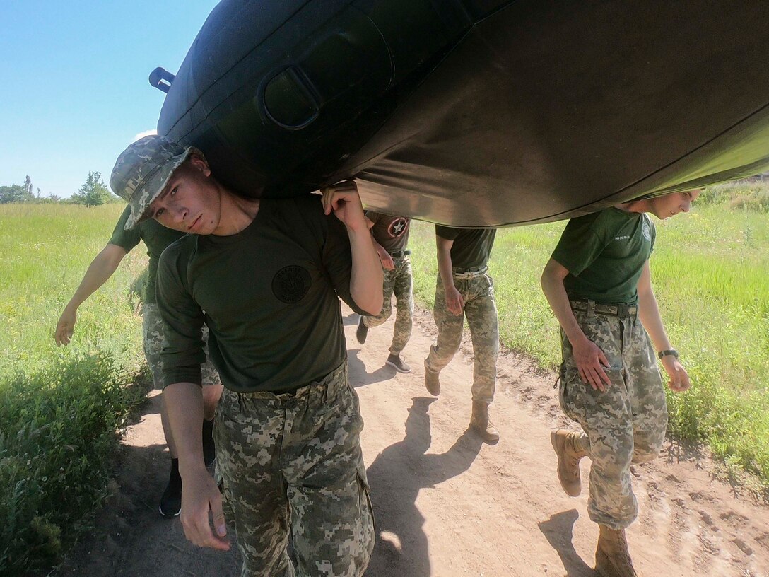 Ukrainian Marines with the 36th Marine Brigade carry a combat rubber reconnaissance craft (CRRC) in Mykolayiv, Ukraine, June 9, 2021. During a nine-day period of instruction, U.S. Marines will teach Marines from Ukraine the basics of operating with the CRRC, a small, lightweight, inflatable, yet rugged boat, useful in a variety of missions requiring speed and stealth. (U.S. Marine Corps photo by Cpl. Claudia Nix)