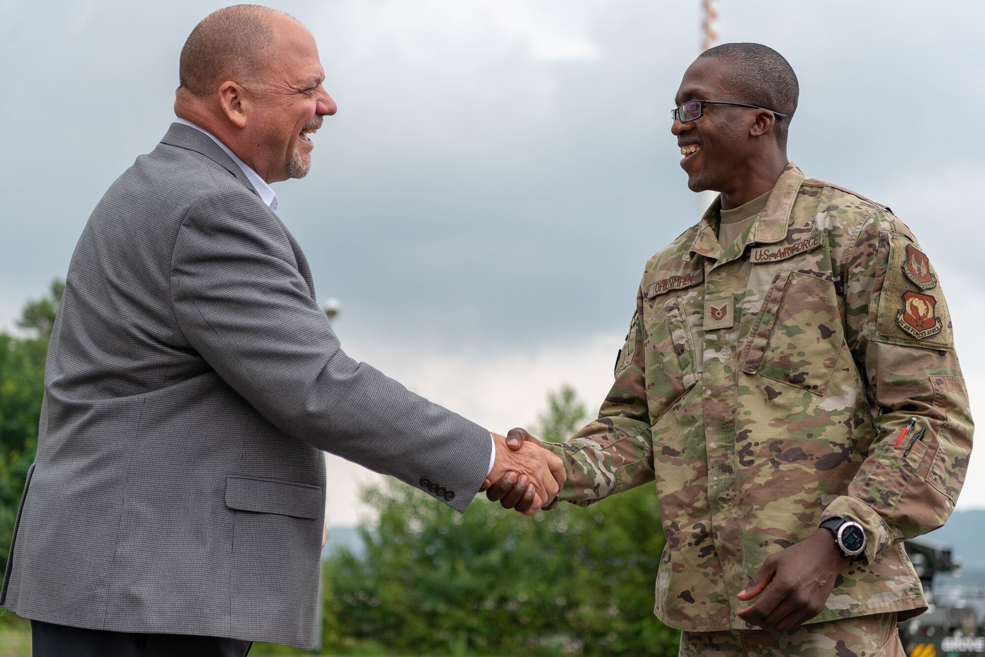 Two men shake hands.