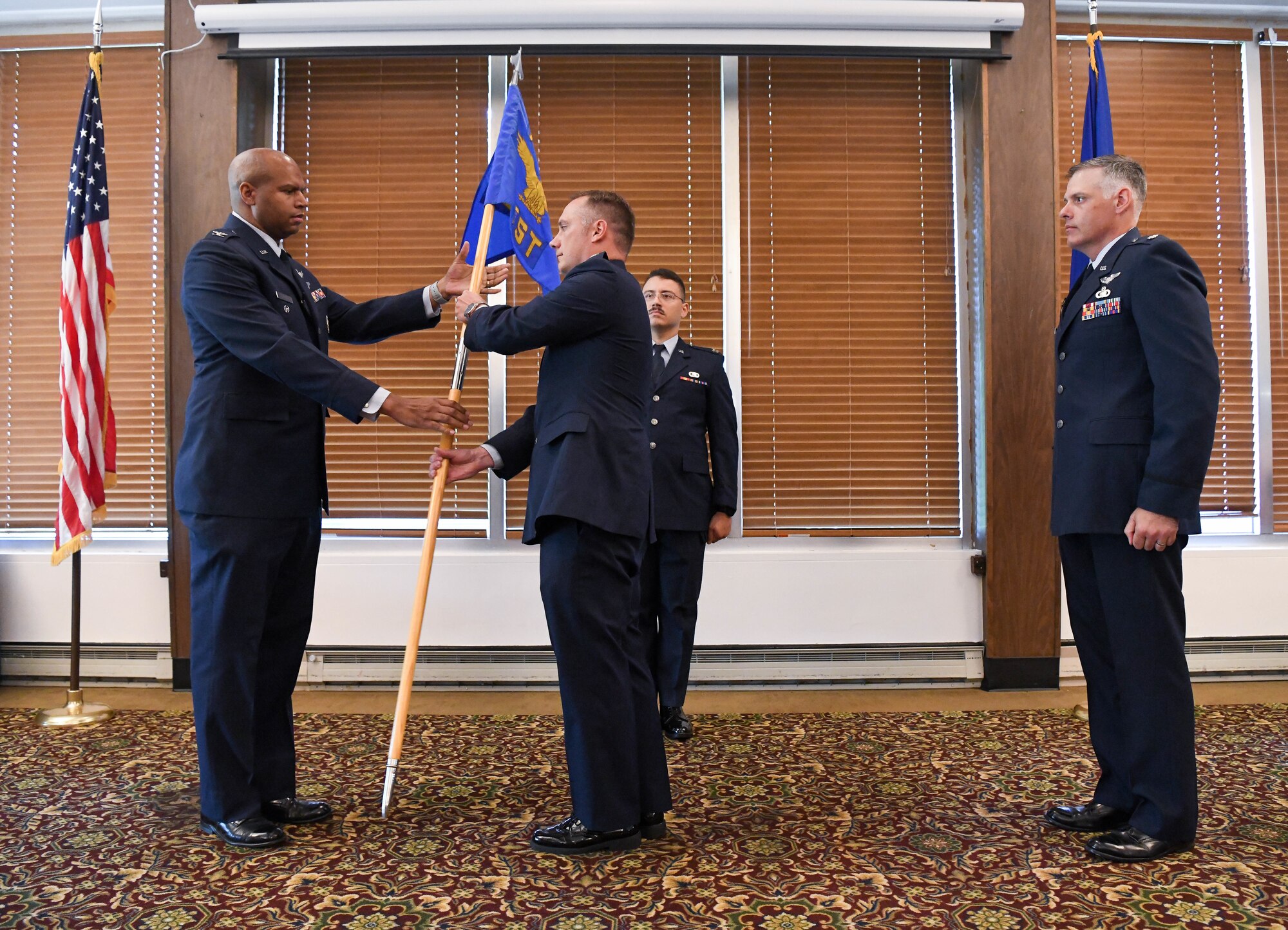 Col. Lincoln Bonner, left, chief of the Arnold Engineering Development Complex Test Division, passes the guidon to incoming Space Test Branch chief, Lt. Col. Dayvid Prahl, after leadership of the Branch was relinquished by Lt. Col. Adam Quick, right, during a Change of Leadership ceremony June 24, 2021, at Arnold Lakeside Complex at Arnold Air Force Base, Tenn. (U.S. Air Force photo by Jill Pickett)