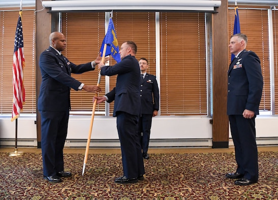 Col. Lincoln Bonner, left, chief of the Arnold Engineering Development Complex Test Division, passes the guidon to incoming Space Test Branch chief, Lt. Col. Dayvid Prahl, after leadership of the Branch was relinquished by Lt. Col. Adam Quick, right, during a Change of Leadership ceremony June 24, 2021, at Arnold Lakeside Complex at Arnold Air Force Base, Tenn. (U.S. Air Force photo by Jill Pickett)