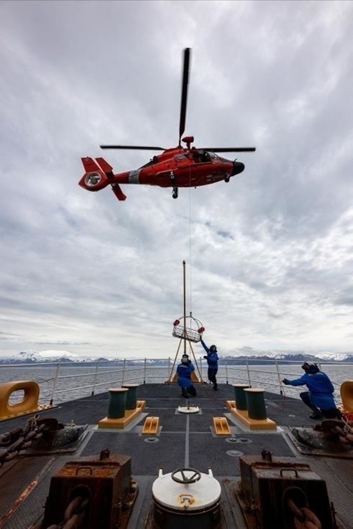 Coast Guard Cutter Alex Haley crew members conduct hoist training with an MH-65 Dolphin helicopter crew while underway in the Bering Sea June 15, 2021. Helicopter crews deploy aboard Coast Guard cutters to extend their search-and-rescue and law-enforcement reach and shorten response times during maritime emergencies. U.S. Coast Guard photo courtesy Coast Guard Cutter Alex Haley.
