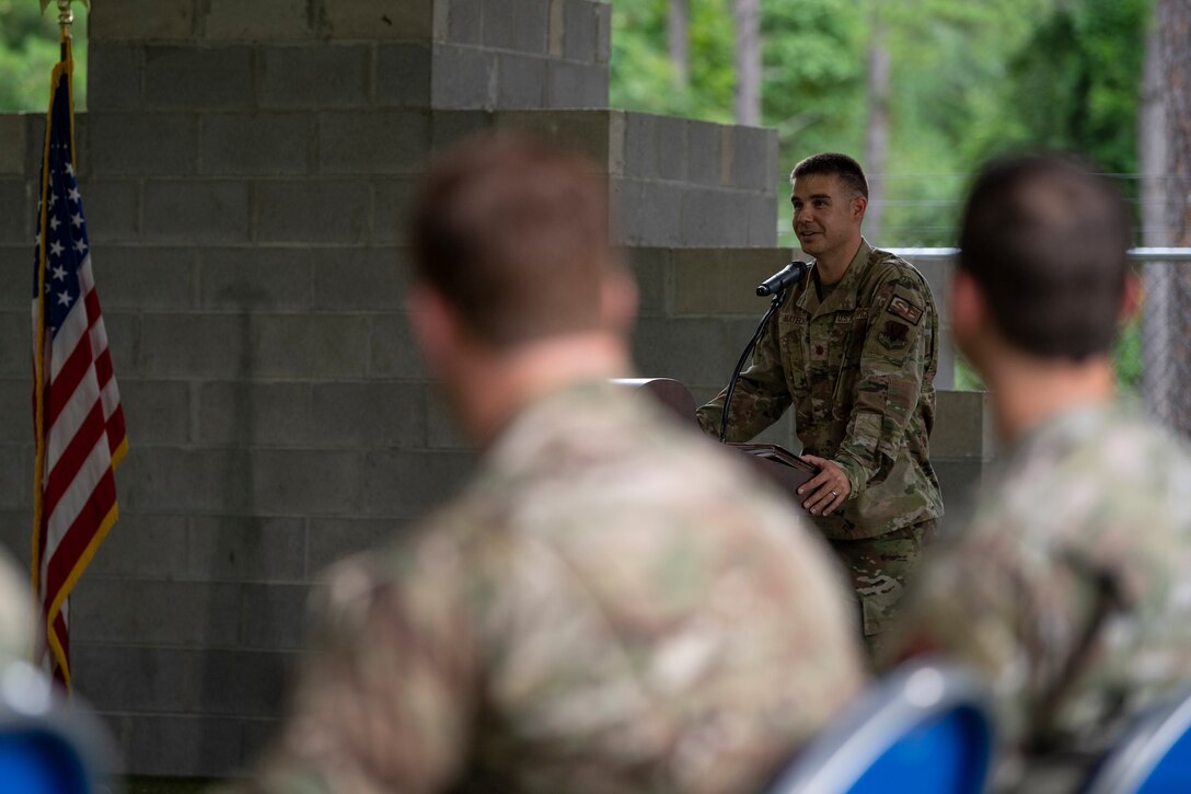 A photo of an Airman standing at a podium.