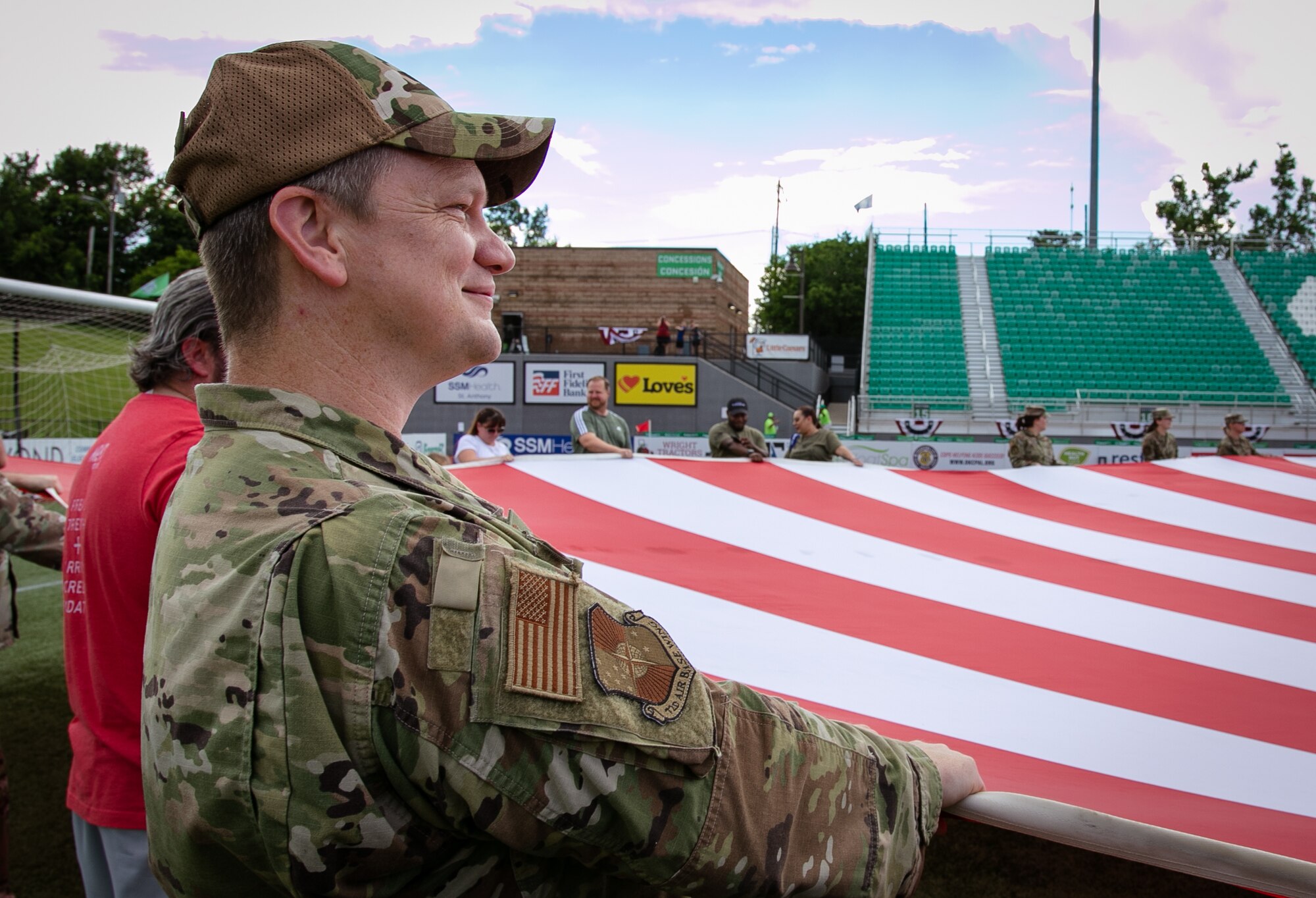 Airman holding a section of a large U.S. flag.