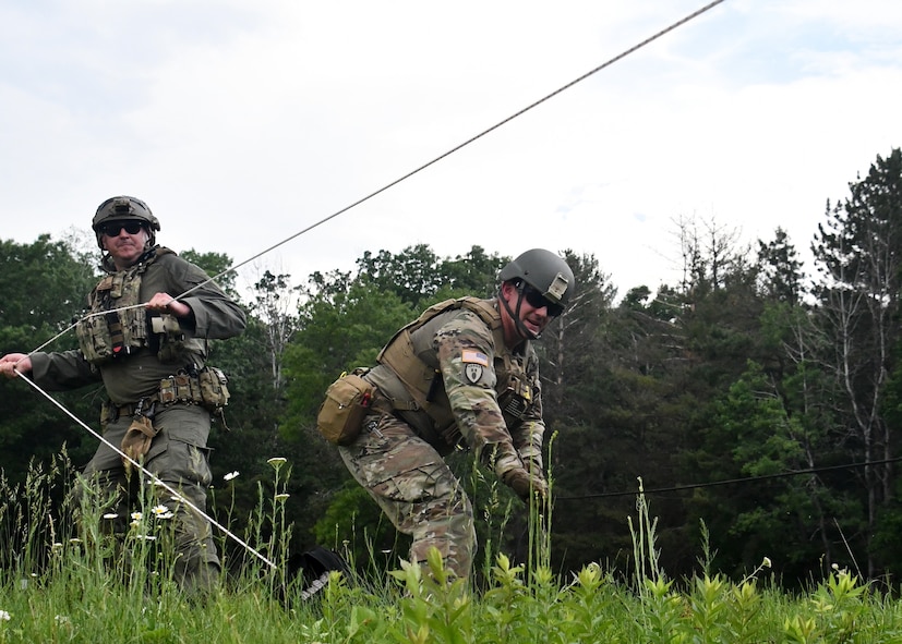 Staff Sgt. Adam Abderrazzaq, 387th explosive ordnance disposal technician, and Michael Rocket, Massachusetts state police department bomb squad trooper, attempt to gain access into a shipping container using remote access techniques during a training scenario at Raven's Challenge Interoperability Exercise June 8, 2021, at Fort Devens Army Base, Devens, Massachusetts. The Soldiers spent a week at the exercise working with civilian public safety bomb squads training in various scenarios, focusing on interoperability between the agencies in operational environments while promoting teamwork and innovation.  (U.S. Air National Guard photo by Senior Airman Sara Kolinski)