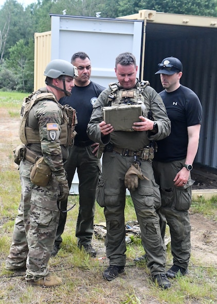 Staff Sgt. Adam Abderrazzaq, 387th explosive ordnance disposal technician, looks at x-rays of a potential explosive taken by the Massachusetts state police department bomb squad during a training scenario at Raven's Challenge Interoperability Exercise June 8, 2021, at Fort Devens Army Base, Devens, Massachusetts. The Soldiers spent a week at the exercise working with civilian public safety bomb squads training in various scenarios, focusing on interoperability between the agencies in operational environments while promoting teamwork and innovation.  (U.S. Air National Guard photo by Senior Airman Sara Kolinski)