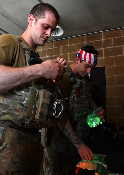Staff Sgt. Randy Burlingame and Senior Airman Josh Torres, 104th Civil Engineering Squadron explosive ordnance technicians, prepare glow in the dark markers for a no light/low light training scenario at Raven's Challenge Interoperability Exercise June 9, 2021, at Fort Devens Army Base, Devens, Massachusetts. The Airmen spent a week at the exercise working with civilian public safety bomb squads training in various scenarios, promoting interoperability between the agencies in operational environments while promoting teamwork and innovation.  (U.S. Air National Guard photo by Senior Airman Sara Kolinski)