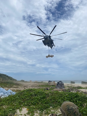 A helicopter drops a fake vehicle on the beach of a tiny island near Okinawa.