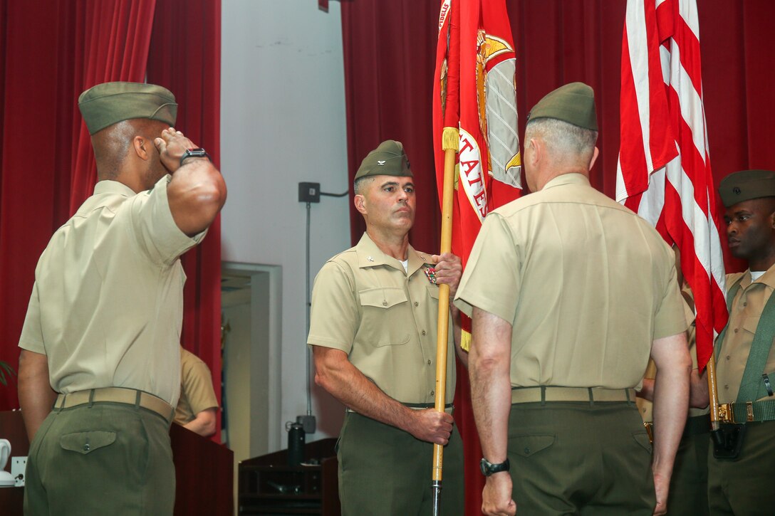 U.S. Marine Corps Col. Edward J. Danielson, commanding officer of Headquarters Battalion, Training and Education Command, and Col. Richard J. Schmidt, incoming commanding officer, prepare to exchange the battle colors during the change of command ceremony at Breckinridge Hall on Marine Corps Base Quantico, Virginia, June 25, 2021. A change of command signifies a formal transfer of authority and responsibility for a unit from one commander to another. (U.S. Marine Corps Photo by Lance Cpl. Mitchell Johnson)