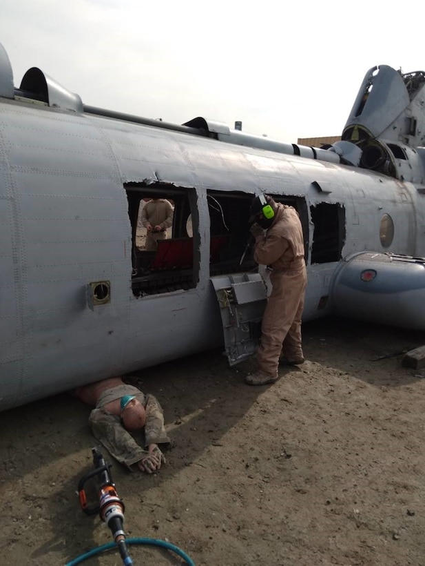 Medics practice passenger extraction using a mannequin and helicopter hull