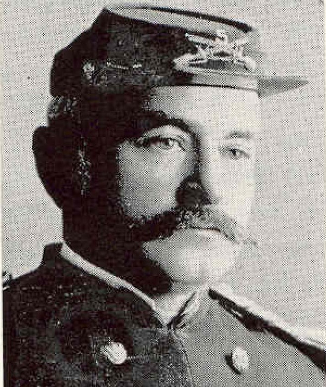 A man in a civil war cap poses for an official photo.