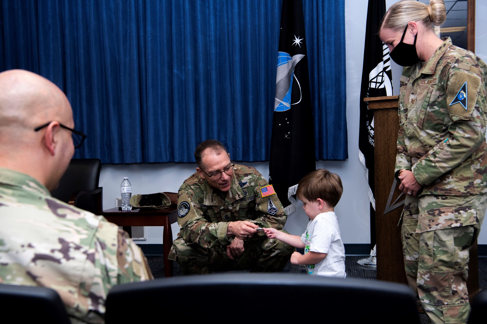Chief Master Sgt. of the Space Force Roger A. Towberman awards his personal coin to Apollo Meza, 3, son of U.S. Air Force Tech. Sgt. Victoria Meza, Vosler Non-Commissioned Officer Academy Professional Military Education instructor at Peterson Air Force Base, Colorado, July 1, 2021. Towberman presented the VNCOA the Department of the Air Force NCOA of the Year award which recognizes outstanding performance and exceptional contributions that support professional military education across the Air Force. (U.S. Space Force photo by Airman 1st Class Joshua Fontenot)