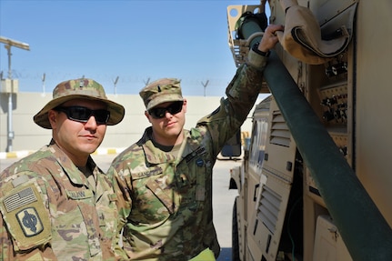 Capt. David Sanders and Chief Warrant Officer 2 Anthony Calanni of the 130th Field Artillery Brigade, Task Force Spartan, outside an AN/TPQ-53 command and control shelter.