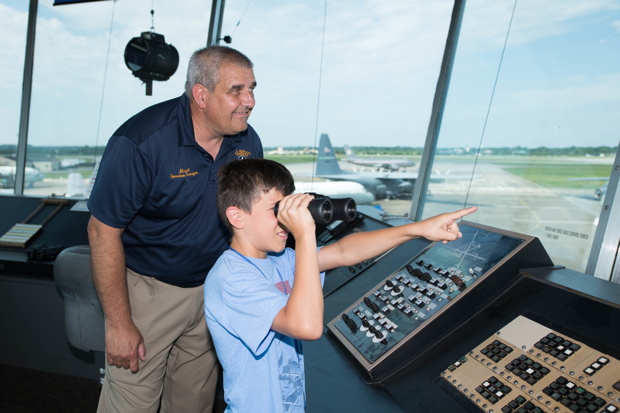 Michael Hurlburt, Air Mobility Command Museum operations manager, and Alex McKenzie watch a Cessna 172 take off during a 2021 Aviation Summer Camp at the AMC Museum in Dover, Delaware, July 1, 2021. During the camp, kids toured the AMC Museum and parts of Dover Air Force Base, in addition to flying in a Dover AFB Aero Club aircraft. (U.S. Air Force photo by Mauricio Campino)