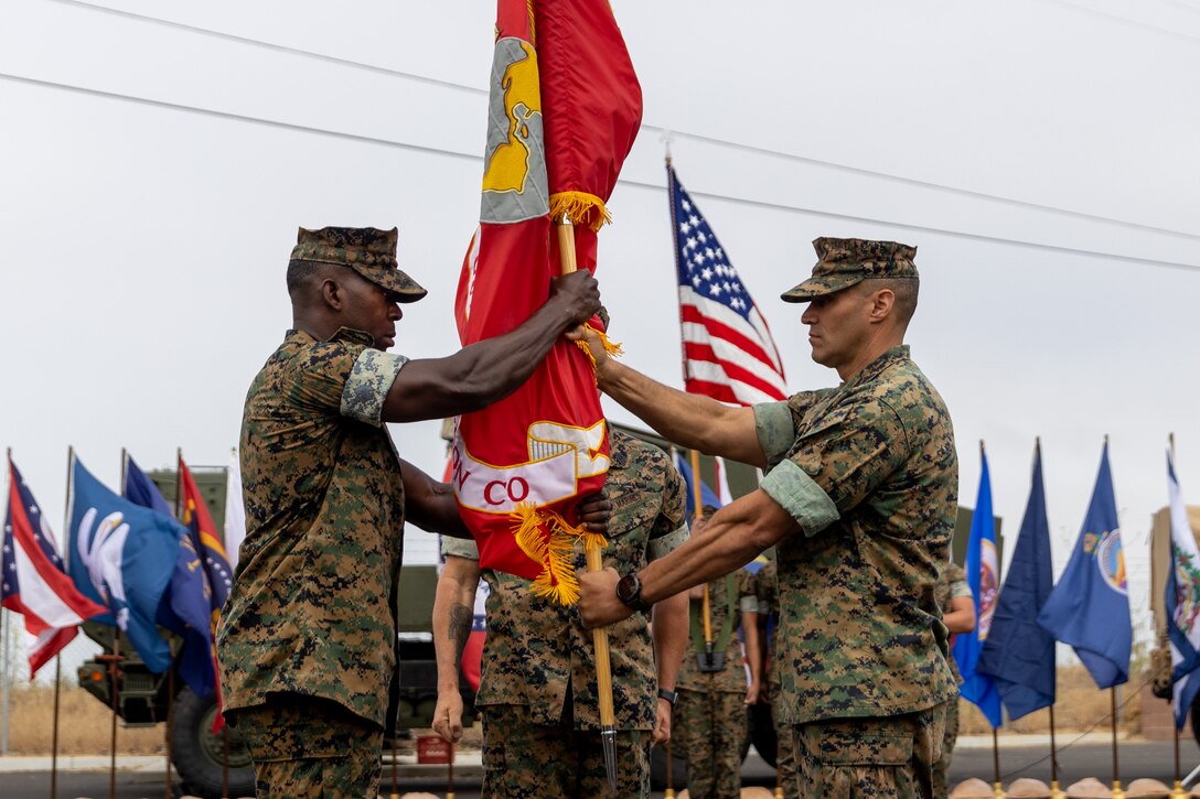 U.S. Marine Corps Lt. Col. Anthony Mercado, right, the outgoing commanding officer of 1st Air Naval Gunfire Liaison Company (1st ANGLICO), I Marine Expeditionary Force Information Group, passes the organizational colors to the oncoming commanding officer of 1st ANGLICO, Lt. Col. McDaniel Sharber during the battalion’s change of command ceremony at Marine Corps Base Camp Pendleton, California, June 30, 2021. The ceremony was held to commemorate the passing of command from Lt. Col. Anthony Mercado to Lt. Col. McDaniel Sharber. (U.S. Marine Corps photo by Lance Cpl. Isaac Velasco)