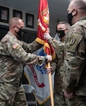 Col. William Wagner (center) accepts the guidon for the 124th Regiment (Regional Training Institute) from Brig. Gen. James Pabis (left) during the 124th RTI's change-of-command ceremony March 6, 2021, at Camp Johnson, Vermont. The 124th RTI is home to the Army Mountain Warfare School, Information Operations Battalion, Officer Candidate Scchool, and the Basic Leaders Course. Also pictured is Command Sgt. Maj. John Digby III (right), the 124th RTI command sergeant major. (U.S. Army National Guard photo by Don Branum)