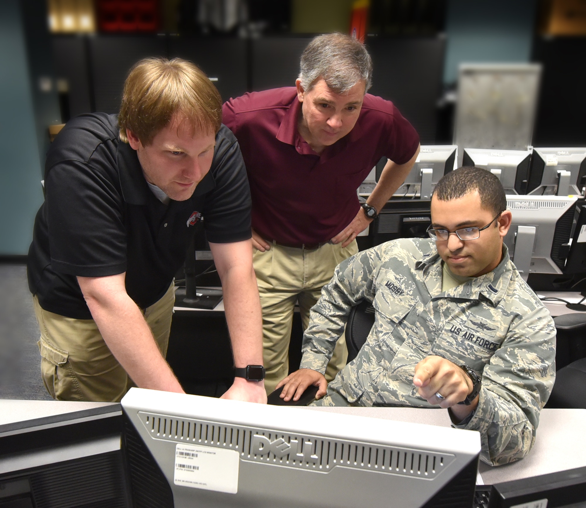(From the left) Ryan Harris, Air Force Institute of Technology computer system administrator and Barry Mullins, AFIT computer engineering professor, observe 1st Lt. Joshua Mosby, AFIT student, as he explains his computer systems hacking technique during the cyberattack class at Wright-Patterson Air Force Base, Ohio, Feb. 20, 2018. Counter insurgency hacking is an espionage attack weapon used to deter enemy threats to national computer communication systems. (U.S. Air Force Photo by Al Bright/Released)