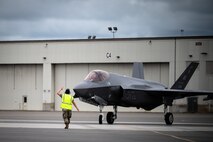 U.S. Air Force Staff Sgt. Michael King, a 356th Aircraft Maintenance Unit crew chief, marshals an F-35A Lightning II assigned to the 355th Fighter Squadron during a hot pit refuelling on Eielson Air Force Base, Alaska, July 7, 2021.