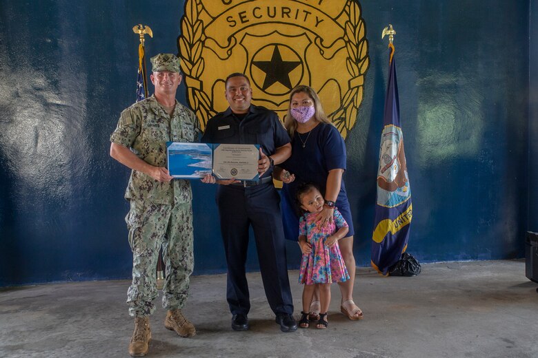 Anton Aguon poses with his family and U.S. Navy Capt. Jeffrey Grimes, commanding officer, U.S. Naval Base Guam (NBG), during a graduation ceremony for newly hired police officers on NBG, July 6, 2021.