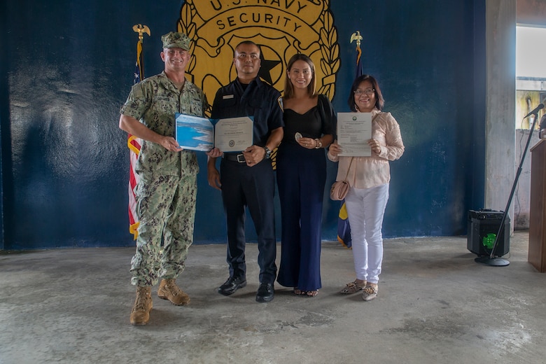 Erano Cortez poses with his family and U.S. Navy Capt. Jeffrey Grimes, commanding officer, U.S. Naval Base Guam (NBG), during a graduation ceremony for newly hired police officers on NBG, July 6, 2021.