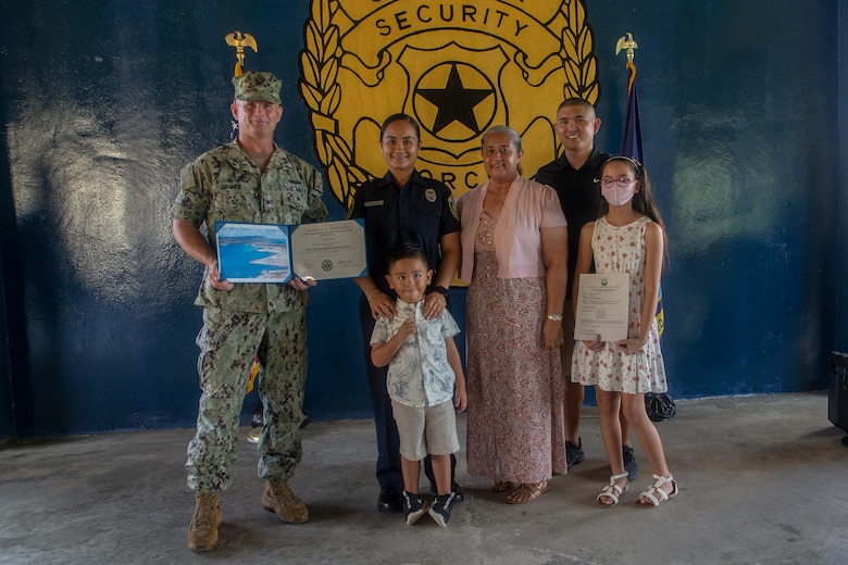 Samantha Santos poses with her family and U.S. Navy Capt. Jeffrey Grimes, commanding officer, U.S. Naval Base Guam (NBG), during a graduation ceremony for newly hired police officers on NBG, July 6, 2021.