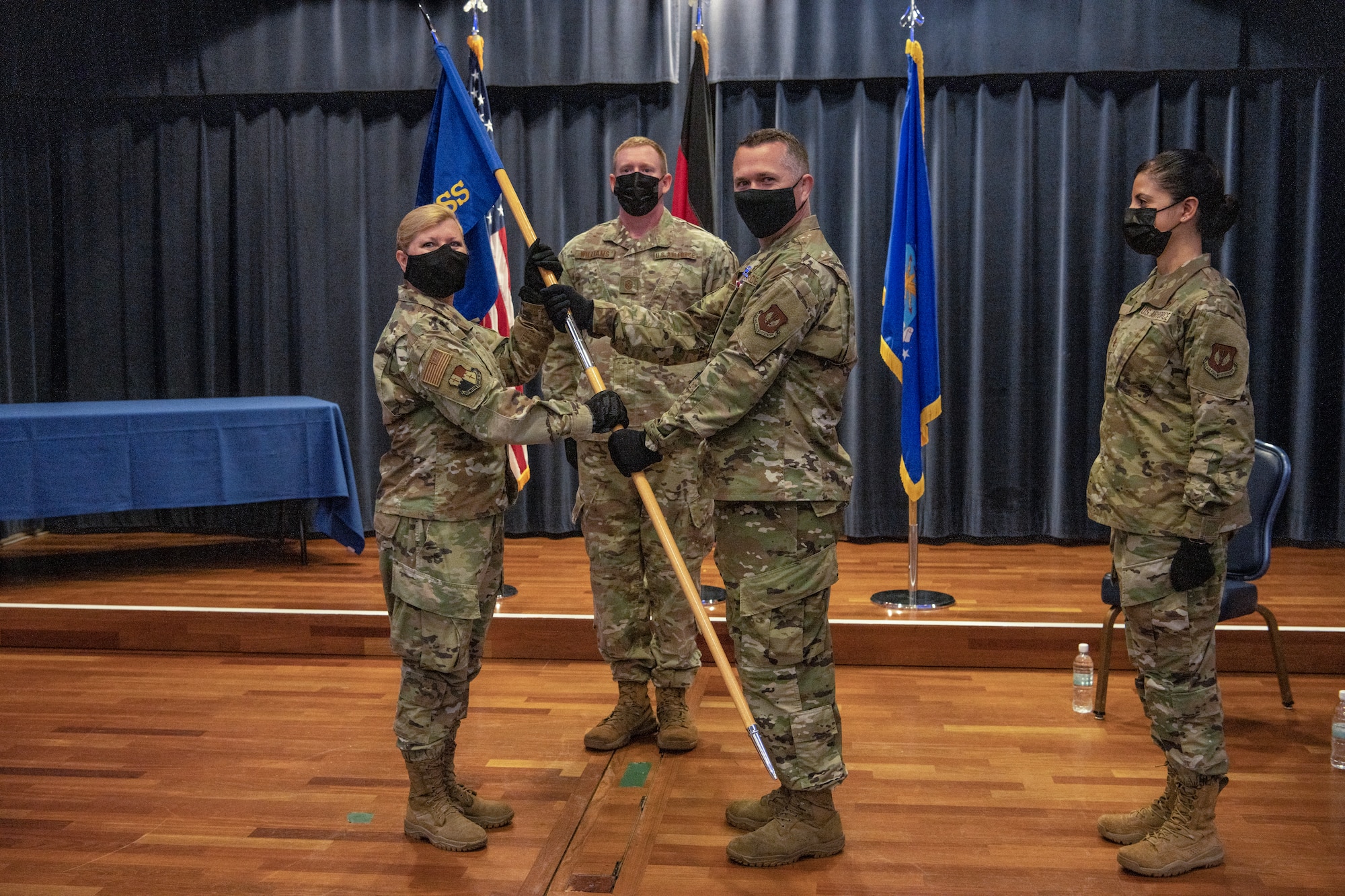 U.S. Air Force Lt. Col. Adam Baker (right), outgoing 52nd Force Support Squadron commander, passes the guidon to U.S. Air Force Col. Betsy Ross, 52nd Mission Support Group commander, at the 52nd FSS change of command ceremony July 6, 2021, on Spangdahlem Air Base, Germany. Baker was commended for facilitating high spirits and fostering morale within the FSS despite the challenges presented by the COVID-19 pandemic. (U.S. Air Force photo by Senior Airman Ali Stewart)